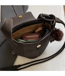 Macro view of dark brown bucket bag showing magnetic closure and spacious interior