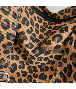Detailed view of leopard print canvas fabric with black zipper and silver hardware