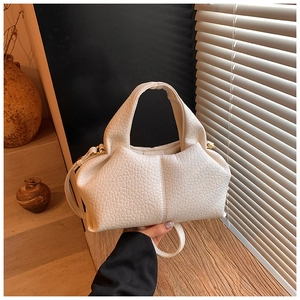Detailed macro view of white lychee texture leather handbag with elegant natural pleats