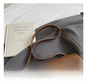 Close-up of retro brown leather tote bag with glossy finish and metal lock detail