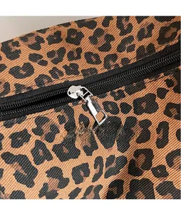 Close-up of sleek silver zipper hardware on a leopard print canvas shoulder bag