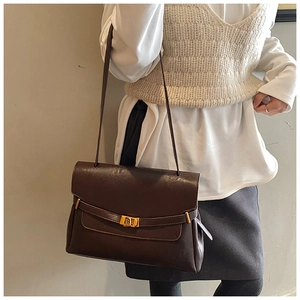 Detail view of large commuter tote bag with gold metal lock buckle on shoulder
