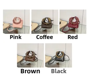 Mini crossbody bags displayed in pink, brown, and red with stylish round handles
