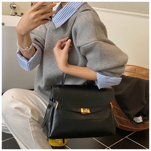 Detailed view of large capacity black tote bag with gold buckle and smooth leather finish