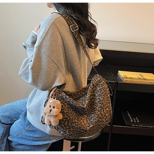 Leopard print hobo bag with teddy bear charm shown on a crossbody shoulder style