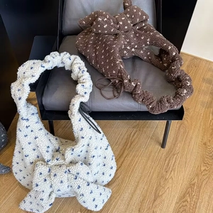 Detailed view of plush lamb fleece tote bags with polka dots and bow accents on a chair