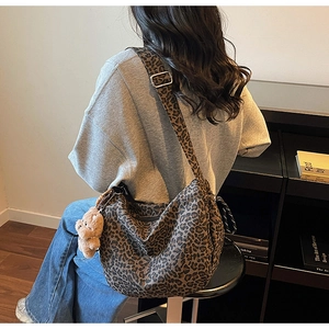 Close-up of leopard print shoulder bag with a cute brown plush bear charm detail