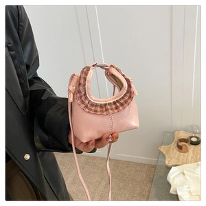 Detailed close-up of pink mini leather bag with plaid ruffle trim and crossbody strap