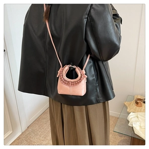 Mini pink crossbody bag with brown plaid ruffle handle detail shown on a model
