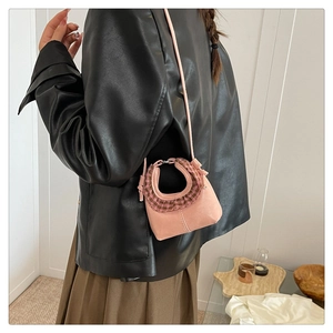 Detailed view of pink mini shoulder bag with ruffled edges and metallic ring handle