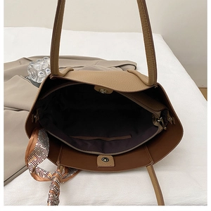 Detail view of khaki tote bag interior with zip pocket, magnetic snap and silk scarf