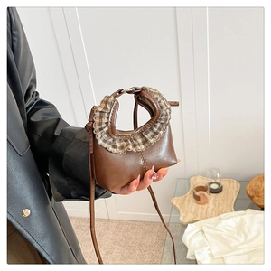 Detail of brown leather mini bag with plaid ruffle handle and slim shoulder strap
