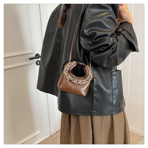 Detailed side view of mini dark brown leather bag with coffee plaid ruffle handle