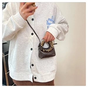 Mini crescent crossbody bag in dark brown with plaid ruffle detail worn by a model