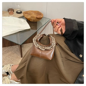 Detailed shot of brown mini bag with ruffled check trim and slim leather handles