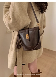 Détail d'un sac seau rétro marron foncé avec fermoir doré et bandoulière en cuir