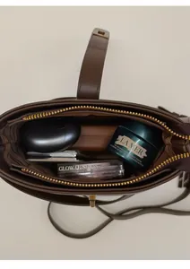 Vue de dessus d'un sac seau en cuir marron foncé montrant l'espace et la fermeture