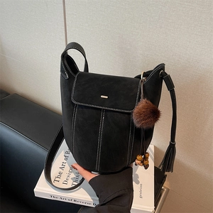 Retro black matte bucket bag with contrast white stitching and decorative charms
