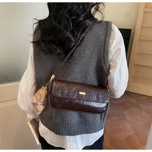 Deep brown retro baguette bag with glossy crinkle leather and cute plush bear charm