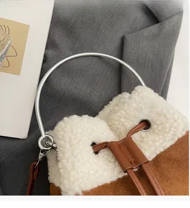 Detail of plush contrast bucket bag with sheepskin trim and round metal handle