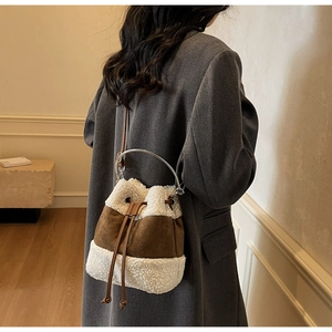Detail of plush contrast bucket bag with brown suede, shearling textures and metal handle