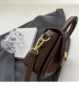 Dettaglio dei ganci in metallo dorato e cuciture su una borsa vintage marrone