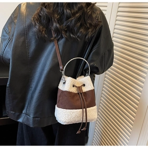 Detail of plush bucket bag featuring white fleece and brown leather with drawstring closure