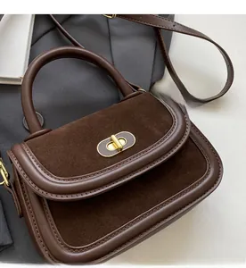 Dettaglio borsa a mano vintage marrone con texture scamosciata e fibbia girevole oro