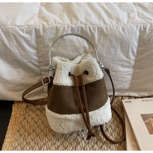 Detail of plush contrast bucket bag with metal ring handle and brown leather drawstring