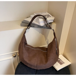 Detailed view of dark brown suede hobo bag featuring wide straps and silver metal zippers