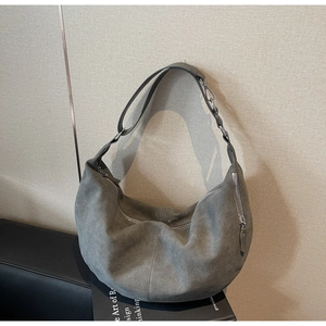 Close-up of grey suede hobo bag with reinforced double stitching and silver zipper detail