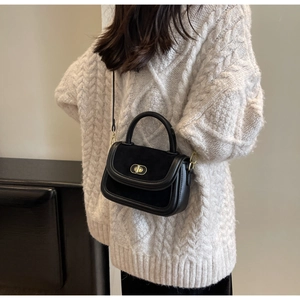Vista laterale di una borsa vintage nera indossata con un maglione autunnale in maglia