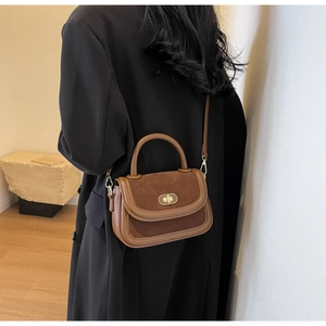 Dettaglio della borsa vintage marrone con chiusura girevole dorata e tracolla