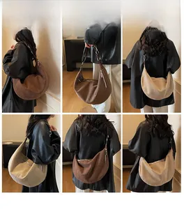 Detail view of large corduroy crescent bags in coffee and beige with adjustable straps