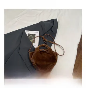 Gros plan du sac en fausse fourrure marron avec fermoir argenté et bandoulière fine