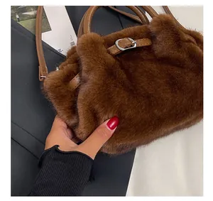 Détail du sac à main en peluche marron foncé avec poignées en cuir et boucle argentée