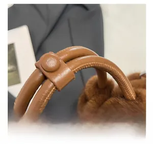 Détail du sac cabas en peluche marron avec anse en cuir et couture de précision