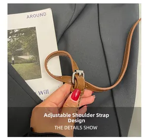 Détail de la bandoulière réglable en cuir marron foncé avec boucle argentée pour sac