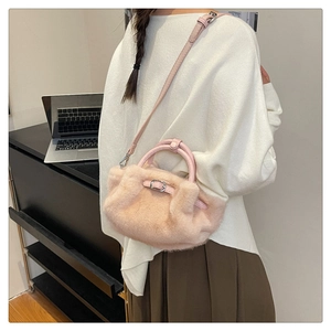 Détail d'un sac à bandoulière en peluche rose avec fourrure synthétique et boucle en métal