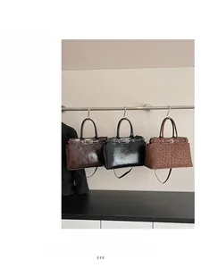 Three stylish handbags in dark brown, black leather, and trendy leopard print suede