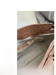 Detail of leopard print tote featuring gold-tone lobster clasp and herringbone lining