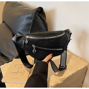 Detail of black rhinestone waist bag featuring silver zippers and chevron patterned strap