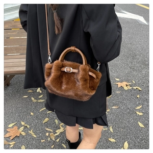 Gros plan du sac à main en peluche marron foncé avec fausse fourrure et détails en cuir