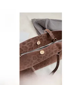Close-up of double magnetic buckle closure on a leopard print tote bag with soft inner lining
