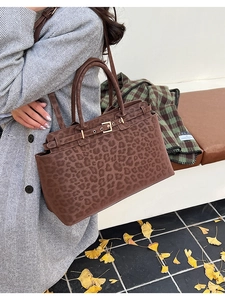 Detail of leopard print tote bag with metal buckle and suede texture in autumn scene