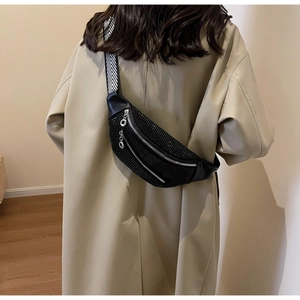 Detail of black rhinestone waist bag with wide geometric strap worn by model