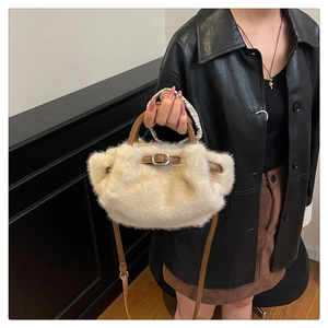 Détail du sac à main en peluche blanc cassé avec anses en cuir marron porté par un mannequin