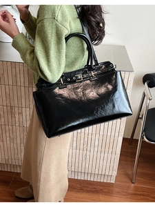 Large black patent leather tote bag shown on model for size and style reference