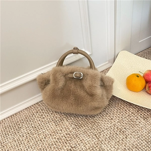 Détail du sac à main en peluche marron avec fausse fourrure et poignée en cuir
