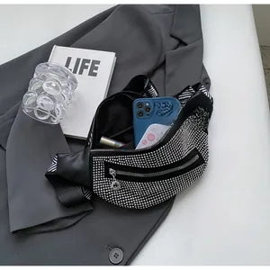 Close-up of black rhinestone belt bag showing spacious interior with phone and lipstick